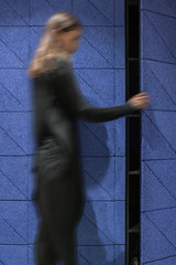 Wall Mural - Woman is opened textured blue door indoors