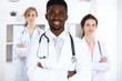 © rogerphoto - Happy african american male doctor  with medical staff at the hospital. Medicine concept
