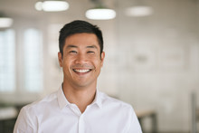 Young Asian Businessman Standing In An Office Smiling Confidently