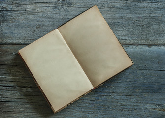 Old open book with blank pages on wood table. Space for text