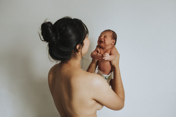 Wall Mural - naked mother holding her infant baby