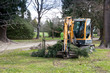 © Sheryl - A work prunes trees along the roadside and uses a digger to clean up the waste in Canterbury, New Zealand