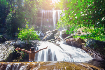 Boy playing waterfall in the forest at Soo Da Cave Roi et Thailand