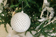 Close up of shiny silver Christmas ball hanging on fir tree branch. Happy New Year background.