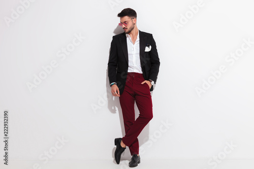 Fotomural relaxed elegant man leaning against wall looks down to side