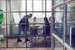 © opolja - Young professional team. Group of young modern people in smart casual wear having a brainstorm meeting while standing behind the glass wall in the creative office.