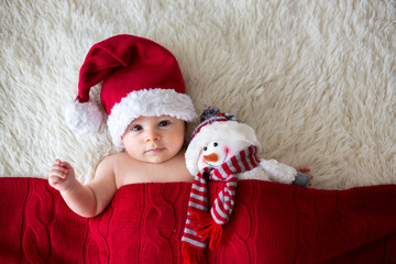 Wall Mural - Christmas portrait of cute little newborn baby boy, wearing santa hat