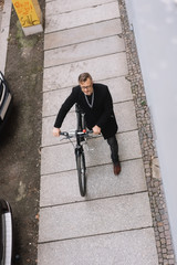 Wall Mural - Mature man walking with bicycle along sidewalk