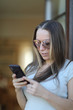 © Anna Jurkovska - Young woman with long hair in sunglasses and phone in hands