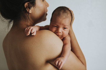 Wall Mural - naked mother holding her infant baby