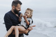 © Rawpixel.com - Father holding his daughter by the sea
