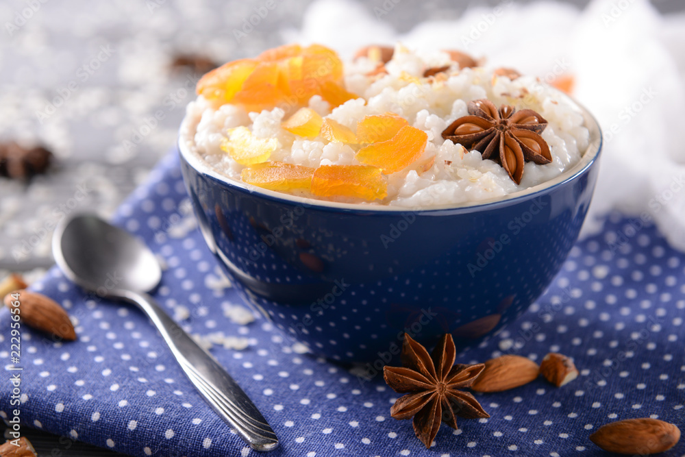 Bowl with delicious rice pudding and dry apricots on napkin