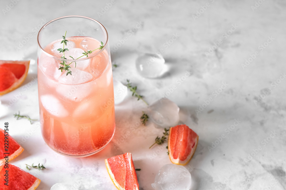 Glass of refreshing grapefruit lemonade on table