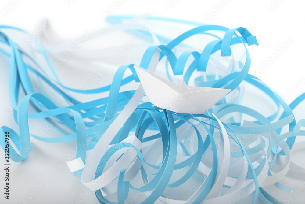 Origami boat on paper ribbons imitating waves