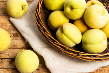 Yellow peaches on rustic wooden table