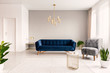Copy space living room interior with a dark blue couch, a gray armchair and gold accents. Real photo.