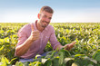 © Zoran Zeremski - Young farmer in field examining soybean corp. He is thumbs up.