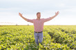 © Zoran Zeremski - Portrait of young farmer standing in soybean field with his arms outstretched.