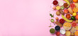 Organic food frame. Banner. Healthy breakfast ingredients. Oat and corn flakes, eggs, nuts, fruits, berries, toast, milk, yogurt, orange, banana, peach on pink background. Top view, copy space