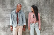 © Friends Stock - Couple shoot. Young diverse couple standing on the city street on wall looking at each other smiling happy