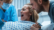 In the Hospital Close-up on Woman in Labor Pushes to Give Birth, Obstetricians Assisting, Husband Holds Her Hand. Modern Delivery Ward with Professional Midwives.