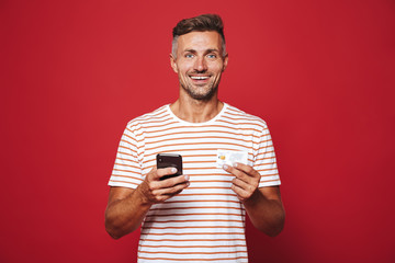 Poster - Portrait of a cheerful man standing over red background