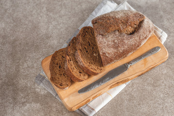 Fresh sliced loaf of rye bread on the wooden cutting board background