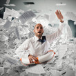© alphaspirit - Businessman with lifebuoy sinks between worksheets in office