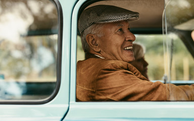 Wall Mural - Senior couple traveling in a vintage car
