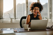 © Jacob Lund - Laughing businesswoman sitting at her work desk