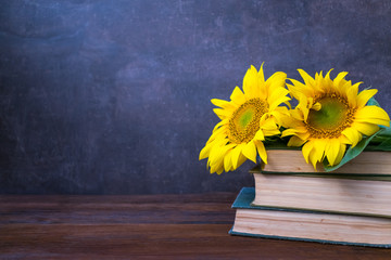 Vintage Old books and bouquet of sunflowers. Two books with bright yellow flowers. Retro nostalgic vintage background. Reading, learning, education, library concept mockup