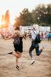 Two female friends jumping around and having fun at music festival