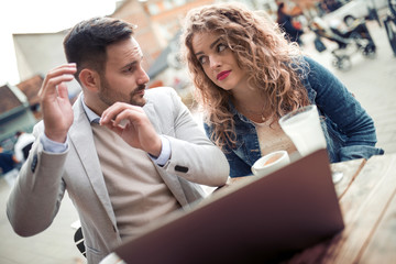 Wall Mural - Young couple with laptop in cafe