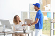 © New Africa - Young woman receiving parcel from courier in office