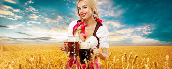 Wall Mural - Beer party. Sexy Oktoberfest woman - waitress, in Munich wearing a traditional german Bavarian dress, serving big beer mugs on golden wheat field background.