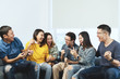 Young Attractive asian group of friends talking and laughing with happy in gathering meeting sitting at home feeling cheerful and enjoy game in leisure time together. People in blue or yellow wearing.