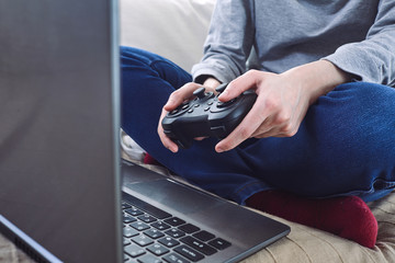 Poster - man holding a joystick controllers while playing a video games at home