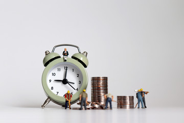 Wall Mural - Miniature laborer with piles of coins. The concept of working hours and wage calculations.