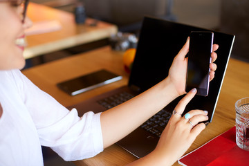 Wall Mural - female scanning fingerprint on her smartphone with laptop on backround. woman unlock mobile phone wi