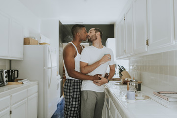 Wall Mural - Gay couple kissing in the kitchen