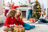 Fototapeta Panele - happy siblings sititng on floor together with gifts during christmas eve