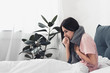 sick young woman sitting in bed and having cough while suffering from sore throat