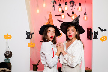 Frightened friends at a Halloween party. Best friends girls celebrates thanksgiving day and Halloween. Happy brightful positive moments of two stylish girls. Surprise.