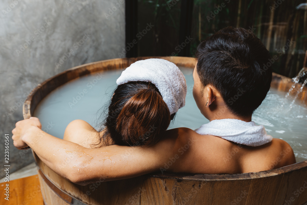 Onsen series: Unrecognizable couple bathing together in wooden bathtub ...