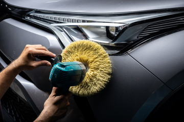 Wall Mural - Car detailing series: Polishing headlights of gray SUV