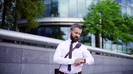 Wall Mural - A portrait of a hipster businessman standing on the street in London. Slow motion.