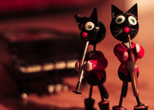 Puppet Cats Playing Instruments On The Scene And The Piano In The Background