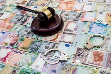 Judge gavel with handcuffs on banknote mix