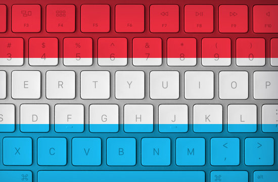 Luxembourgish flag and computer keyboard in the background. Luxembourg flag