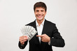 © Drobot Dean - Happy businessman standing isolated holding money pointing.